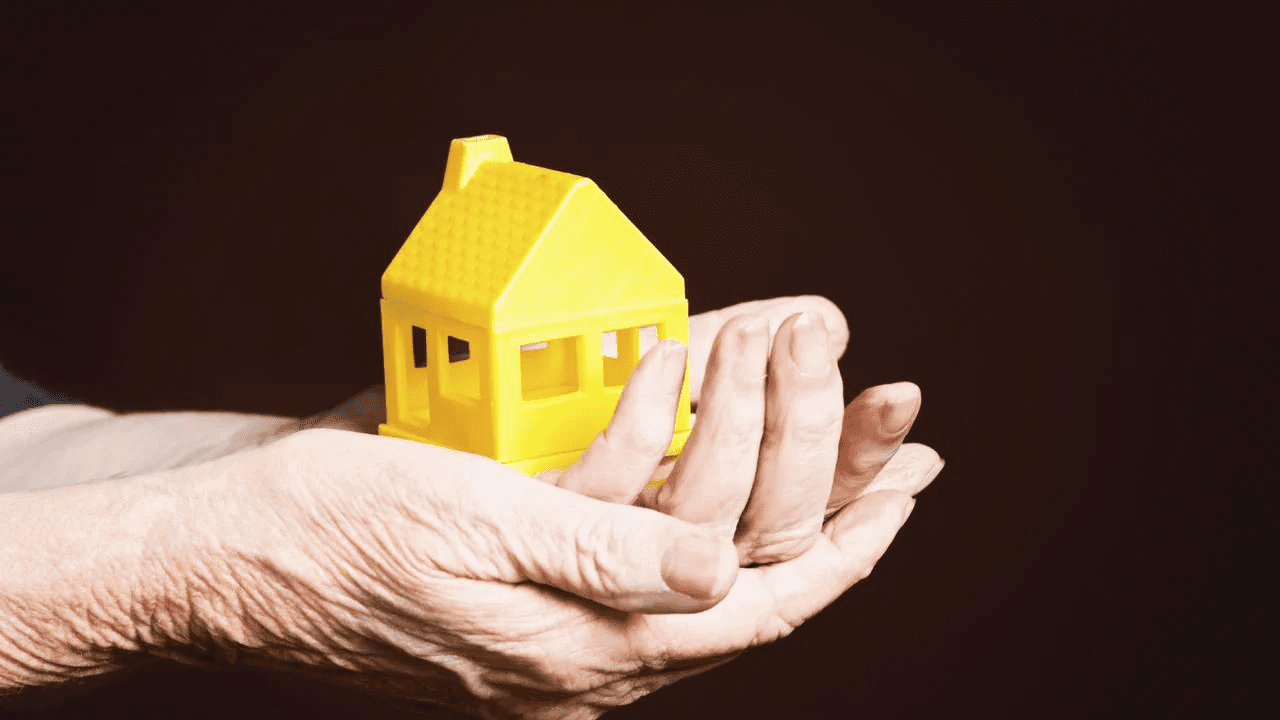 Senior lady's hands cupping a house