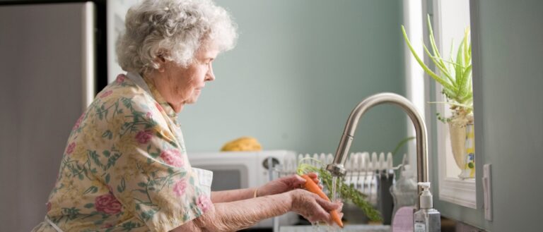 Elder pensioner washing vegetables