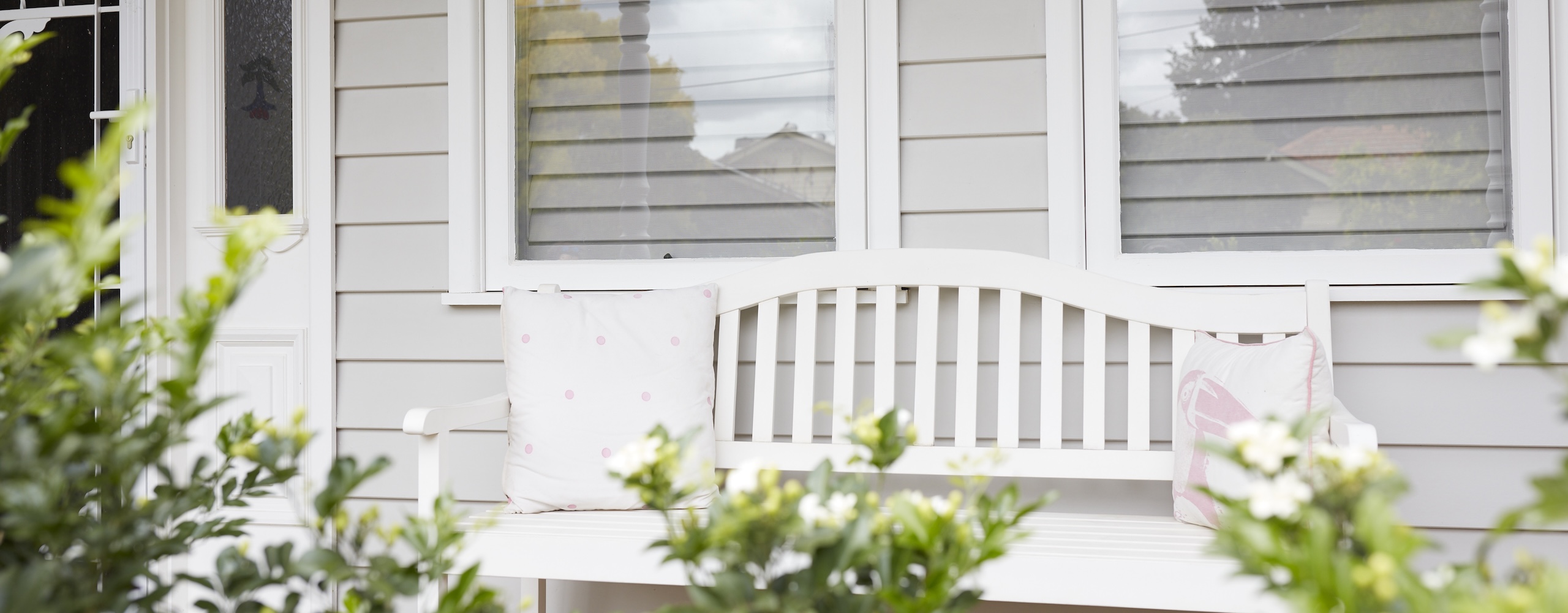 An empty bench seat at the front of a house