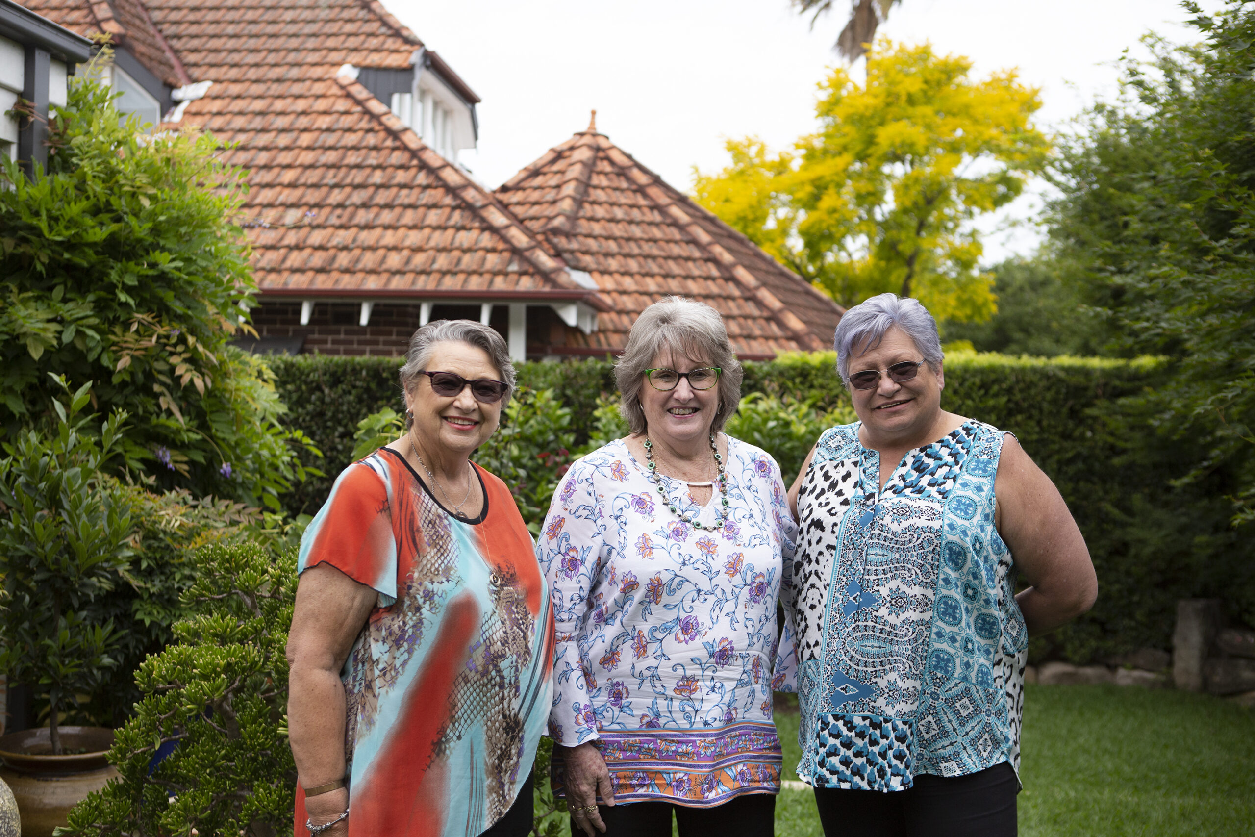 3 ladies standing in a backyard